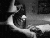 a man in a top hat stands in front of a bed