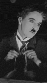 a black and white photo of a man in a suit and tie .