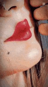 a close up of a woman 's face with red lips and a nose ring