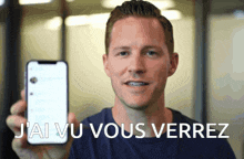 a man is holding up a cell phone with the words j'ai vu vous verrez written on the bottom