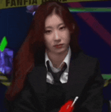 a woman in a suit and tie is holding a pen .