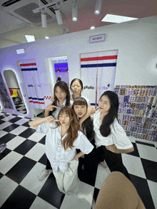 a group of girls pose in front of a sign that says kitsch on it