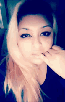 a close up of a woman touching her face