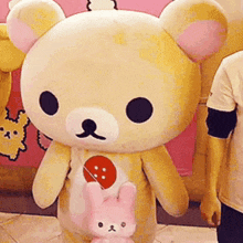 a large teddy bear with a pink bunny in its pouch