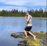 a man is standing on a cliff overlooking a lake