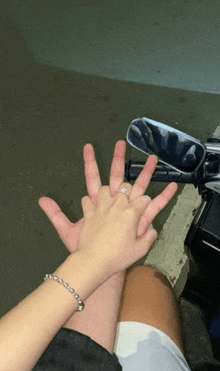 a man and a woman are holding hands and the woman is wearing a ring