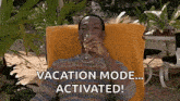 a man is sitting in a chair drinking a glass of wine and says `` vacation mode ... activated ! ''