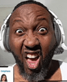 the man is wearing headphones and making a funny face .
