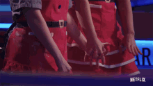 a netflix ad shows two women holding hands in red aprons