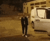a man standing in front of a white van with the door open
