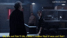 a gif from gifrun.com shows a man and a woman standing in a dark room