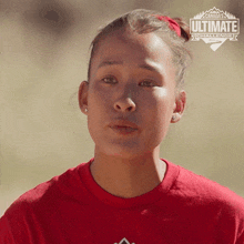 a woman wearing a red shirt with the word ultimate on it
