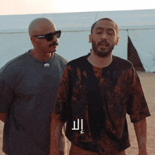 two men standing next to each other with one wearing sunglasses and the other wearing a shirt that says dolce & gabbana