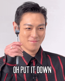 a man in a striped shirt is holding a fork with the words oh put it down written below him