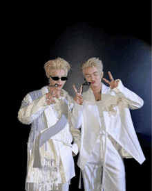 a couple of men standing next to each other wearing white clothes