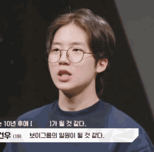 a man wearing glasses and a blue shirt is talking in a video