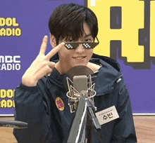 a man wearing sunglasses is giving a peace sign