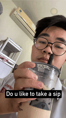 a man wearing glasses is holding a cup with a straw and the words do u like to take a sip below him
