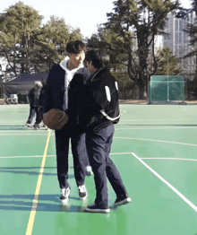 a man in a black jacket with the number 1 on the back is holding a basketball