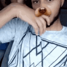 a young man is holding a dog nose in his hand .