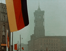a clock tower is visible in the distance behind a flag