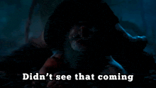 a man with a beard is crawling in the dark with the words didn 't see that coming behind him