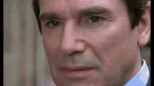 a close up of a man 's face with a slight smile on his face