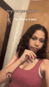 a girl in a pink tank top is taking a selfie in front of a mirror ..