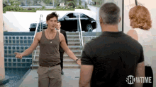 a man in a tank top is standing next to another man in a showtime shirt