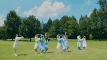 a group of young girls are dancing in a field