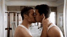 two men are kissing each other in front of a mirror .