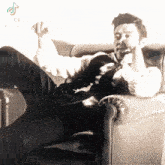 a man in a suit and tie is sitting in a chair and smoking a cigarette