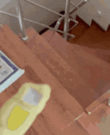 a wooden staircase with a metal railing and a yellow object on the bottom step