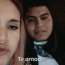 a man and a woman are standing next to each other and the woman is saying te amoo .