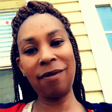 a woman with braids and a cross on her forehead