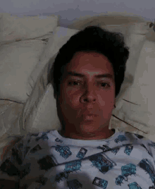 a man is laying on a bed wearing a shirt that says ' coca cola '