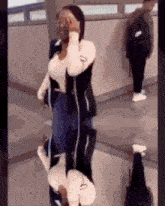 a woman is standing in front of a mirror and covering her face .