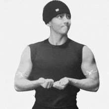 a man wearing a black tank top has a pair of scissors on his arms