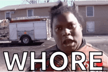 a man is standing in front of a fire truck and the word whore is on his chest