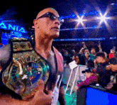 a man wearing sunglasses is holding a wrestling championship belt