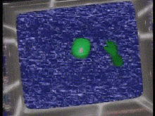 a green frog is sitting on a purple surface