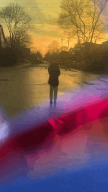 a person walking down a street at sunset