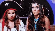 two women dressed in pirate costumes are looking at the camera