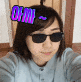 a woman wearing sunglasses has a sticker on her forehead that says om