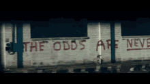 a brick wall with the words " the odds are never in " written on it