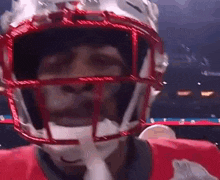 a football player wearing a helmet with his eyes closed .