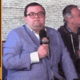 a man in a blue suit is holding a microphone with the word nbc on it