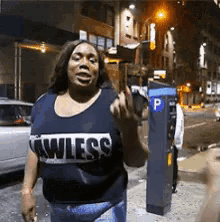 a woman wearing a shirt that says ' awless ' is walking down a street