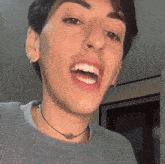 a close up of a man 's face with his mouth open and a choker around his neck