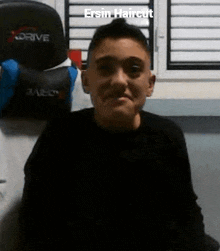 a young boy with a shaved head is sitting in front of a computer chair .